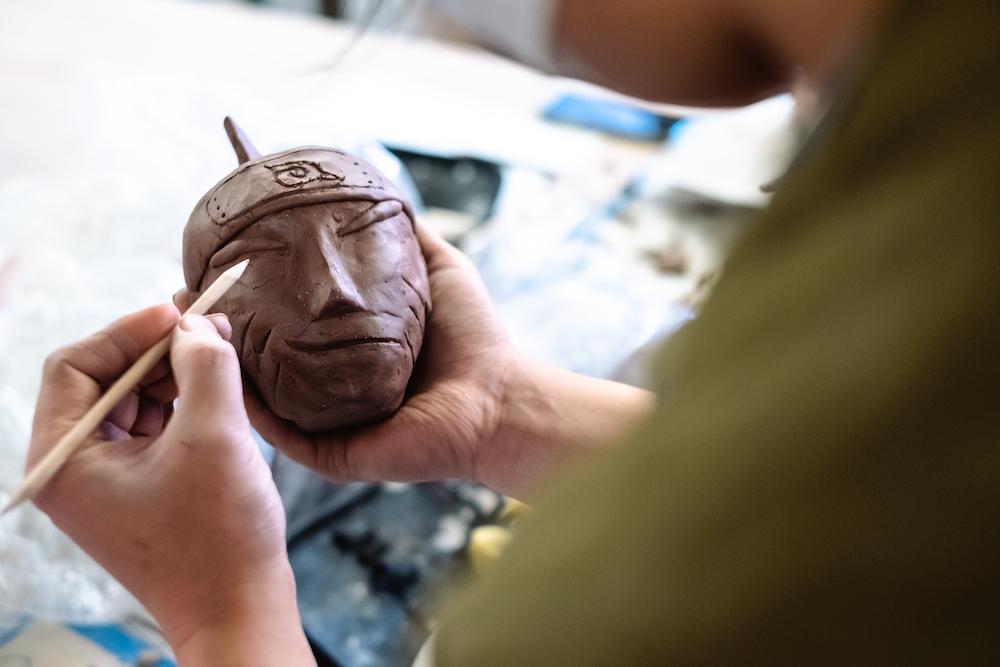 Student shaping a ceramic Shinobi of the Leaf Village