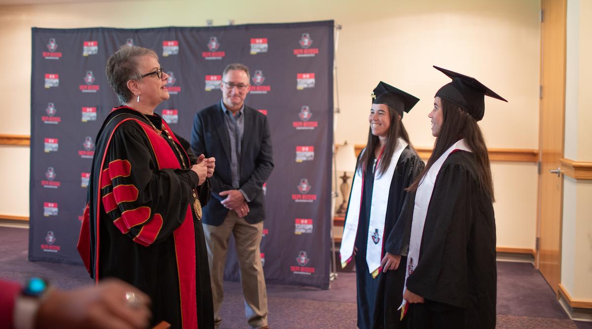 Austin Peay President Alisa White talks to Lidia Yanes Garcia, left, and Claudia Yanes Garcia prior to their commencement.